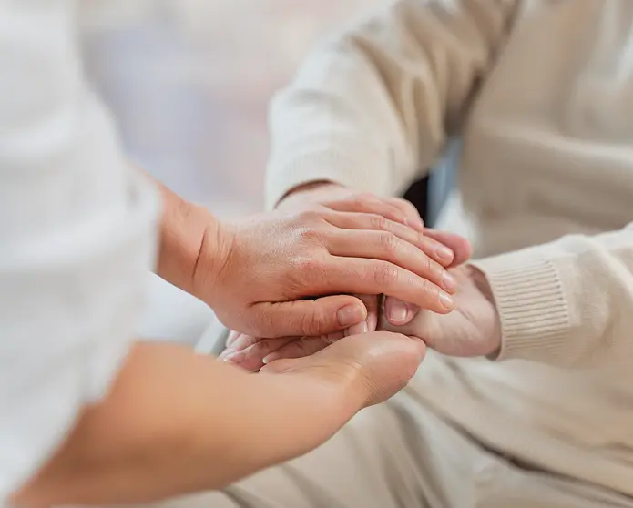 Healthcare professional supporting a patient's hand